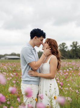 Couple standing forehead to forehead in a wildflower meadow
